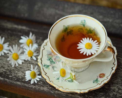 A cup of herbal tea and fresh fruits on a wooden table