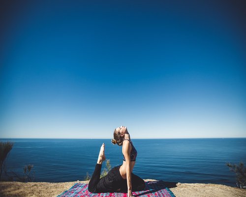 Woman performing gentle morning stretching in a sunny garden